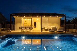 A covered outdoor area with a pool, seating, and a door leading to an interior space. - House Vrsinka (Marina)