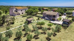 A residential area with a large house, a smaller building with a tower, and a gazebo. - Apartment Gradina (Vodnjan)