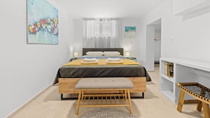 A bedroom with a bed, bedside tables, a bench, and a bookshelf. - Apartment Gradina (Vodnjan)