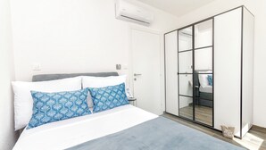 A bedroom with a bed, a wardrobe, and an air conditioning unit. - Apartments Sunny (Vodice)