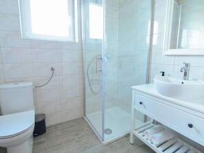 A modern bathroom with a glass shower enclosure, a white sink, and a toilet. - Apartment Vransko (Pirovac)