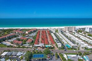 An aerial view of a coastal hotel with multiple buildings, a beach, and a road. - Casa Blanca - Villa D06 (Sarasota)