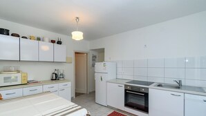 A compact kitchen with white cabinets, a microwave, a coffee maker, a refrigerator, and a dishwasher. - House Toni (Rab)