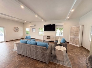 A spacious living room with a large sofa, a coffee table, and a flat-screen TV mounted on the wall. - Casa Blanca  - Villa A14 (Sarasota)