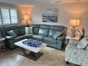 A living room with a sectional sofa, a coffee table, a side table with a lamp, and a painting on the wall. - Casa Blanca  - Villa A14 (Sarasota)