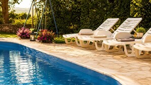 A swimming pool with lounge chairs and a hanging planter. - House Ivana (Krsan)