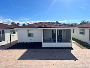 A single-story house with a tiled roof, a covered patio area, and a small window. - Casa Blanca - Villa B03 (Sarasota)
