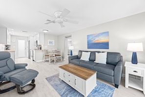 A modern living room with a grey sofa, a wooden coffee table, and a blue patterned rug. - Casa Blanca - Villa B08 (Sarasota)
