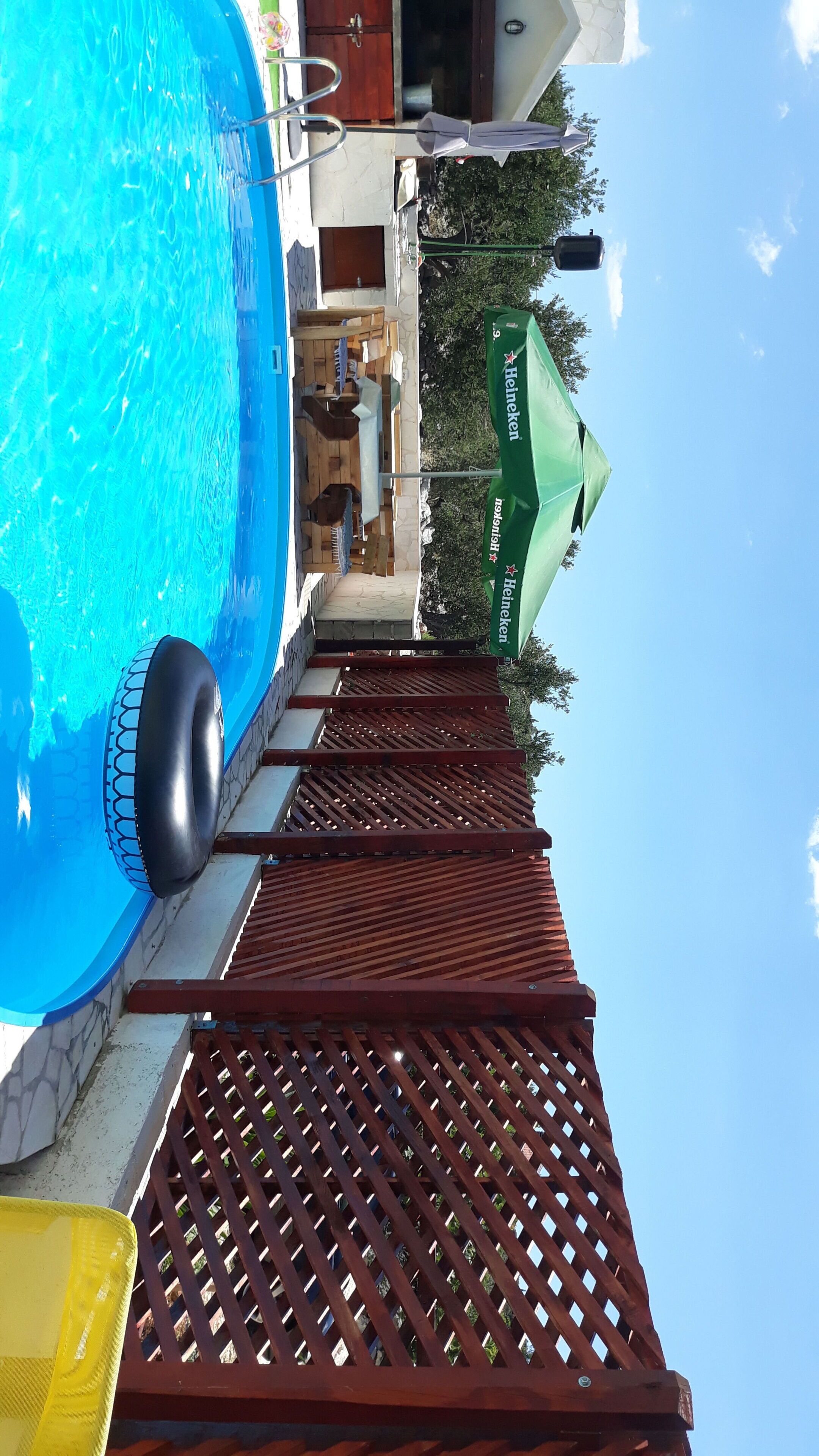 Outdoor pool, a heated pool, pool umbrellas, pool loungers