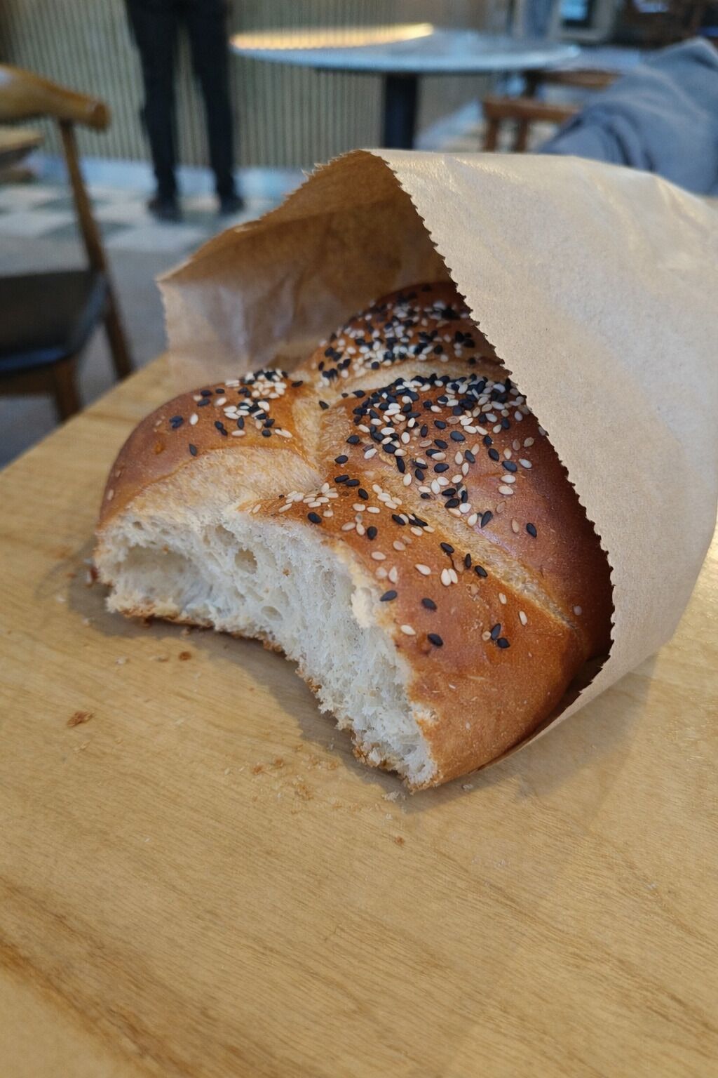 A loaf of bread with sesame seeds on a wooden cutting board.