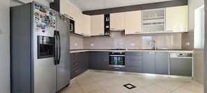 A modern kitchen with grey cabinets, a built-in oven, and a dishwasher. - Apartment On the top (Jelsa)