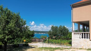 A coastal property with a stone wall, a balcony, and a view of the sea. - House Sea and River (Obrovac)