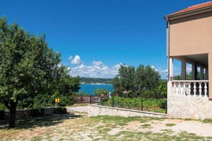 A coastal property with a stone wall, a balcony, and a view of the sea. - House Sea and River (Obrovac)