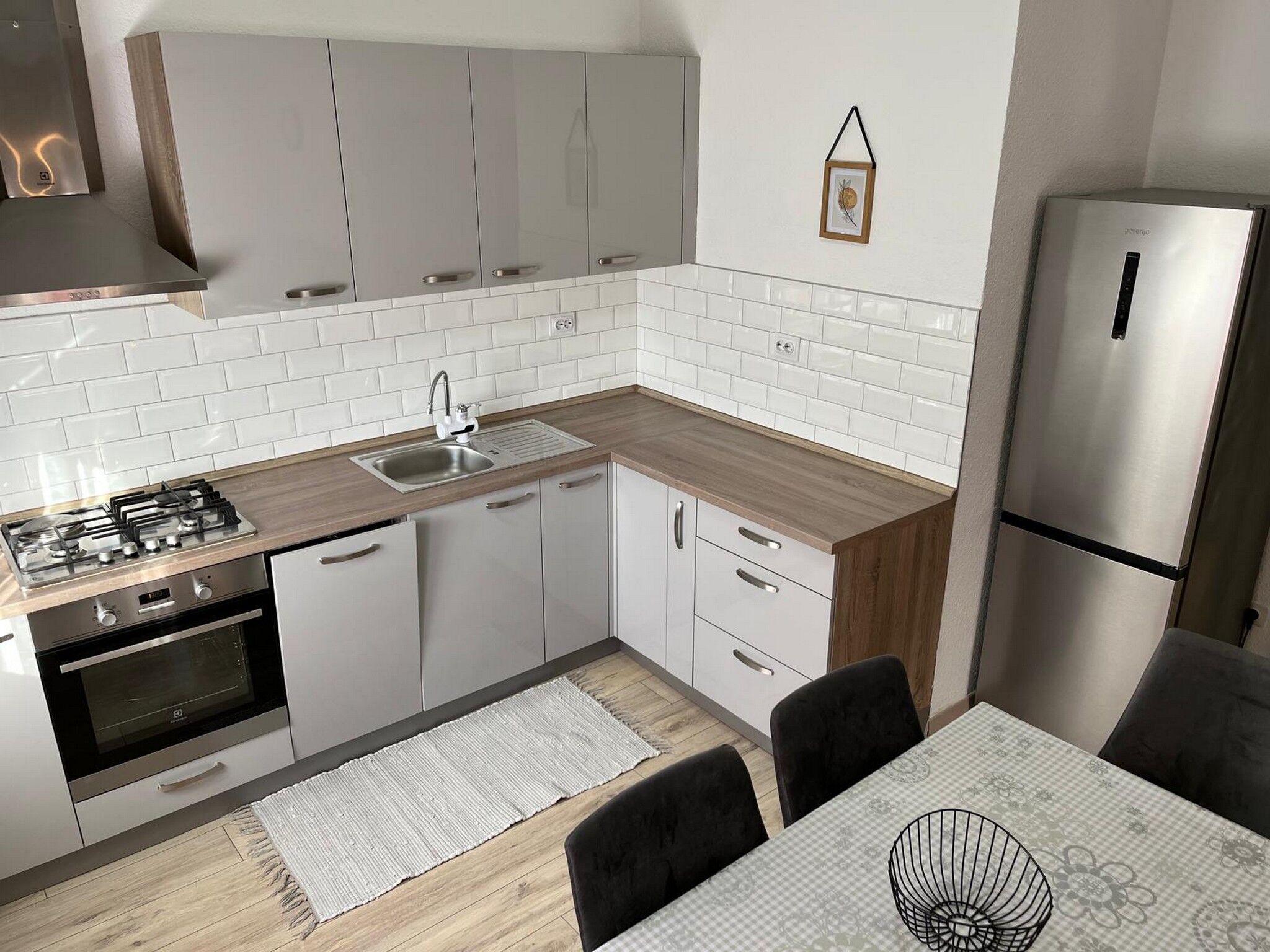 A modern kitchen with white cabinetry, a stainless steel refrigerator, and a gas stove.