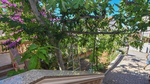 A balcony with a view of a garden and street. - Apartments Immortelle (Biograd na Moru)