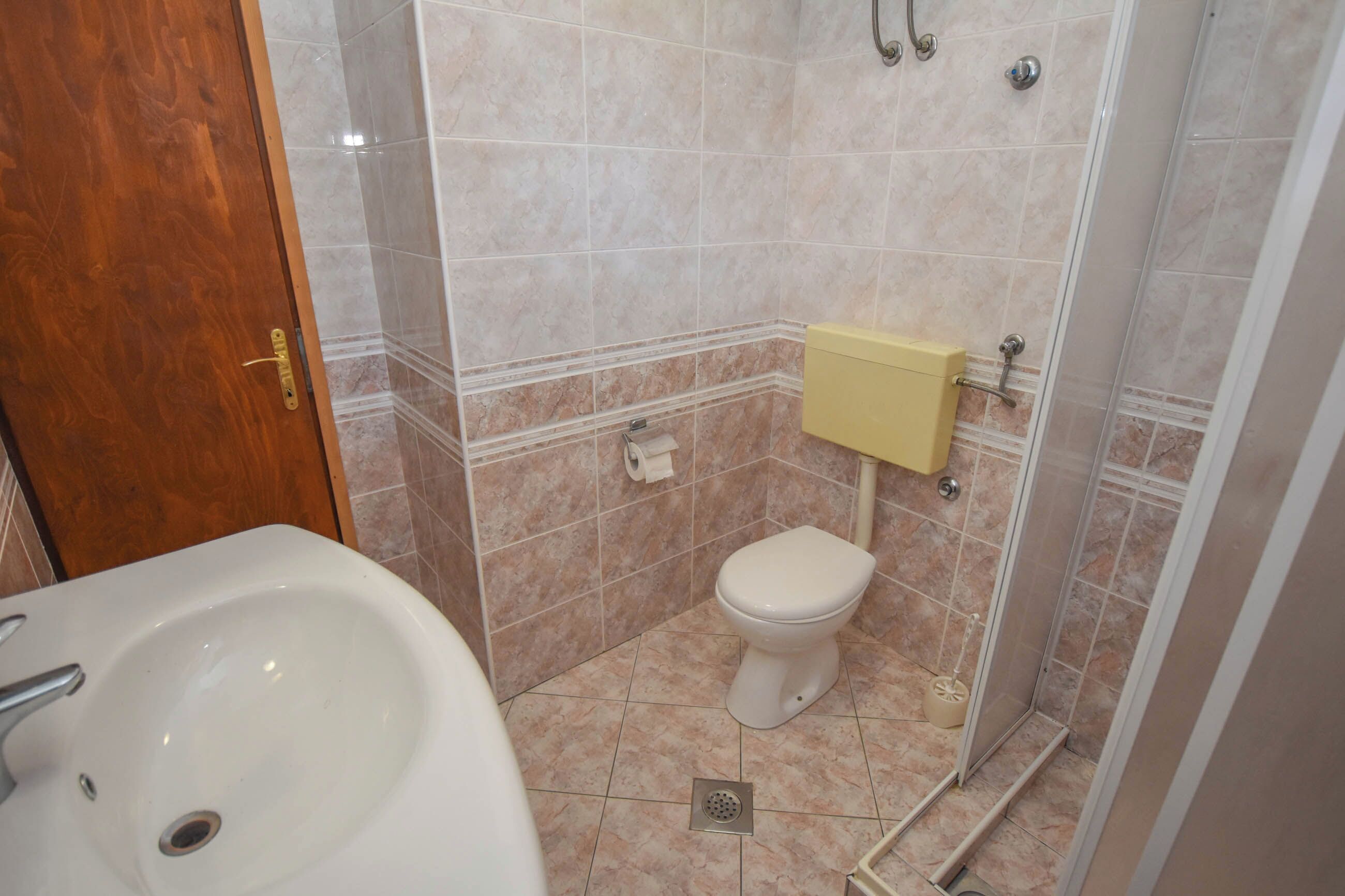 Ein Badezimmer mit Waschbecken, Toilette und Duschbereich.