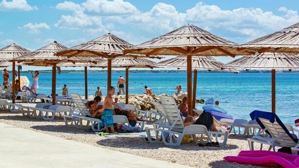 A beach with sun loungers and thatched umbrellas. - Apartment Ivana With Jacuzzi (Vir)