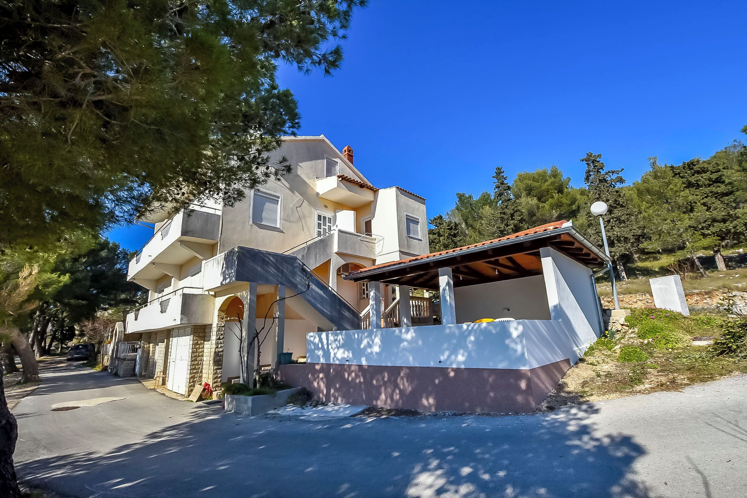 Une maison à deux étages dotée d’un balcon, d’un porche couvert et d’une allée.