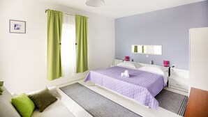 Ein Schlafzimmer mit einem Bett, einem Nachttisch, einem Spiegel und einem Fenster mit Vorhängen.
