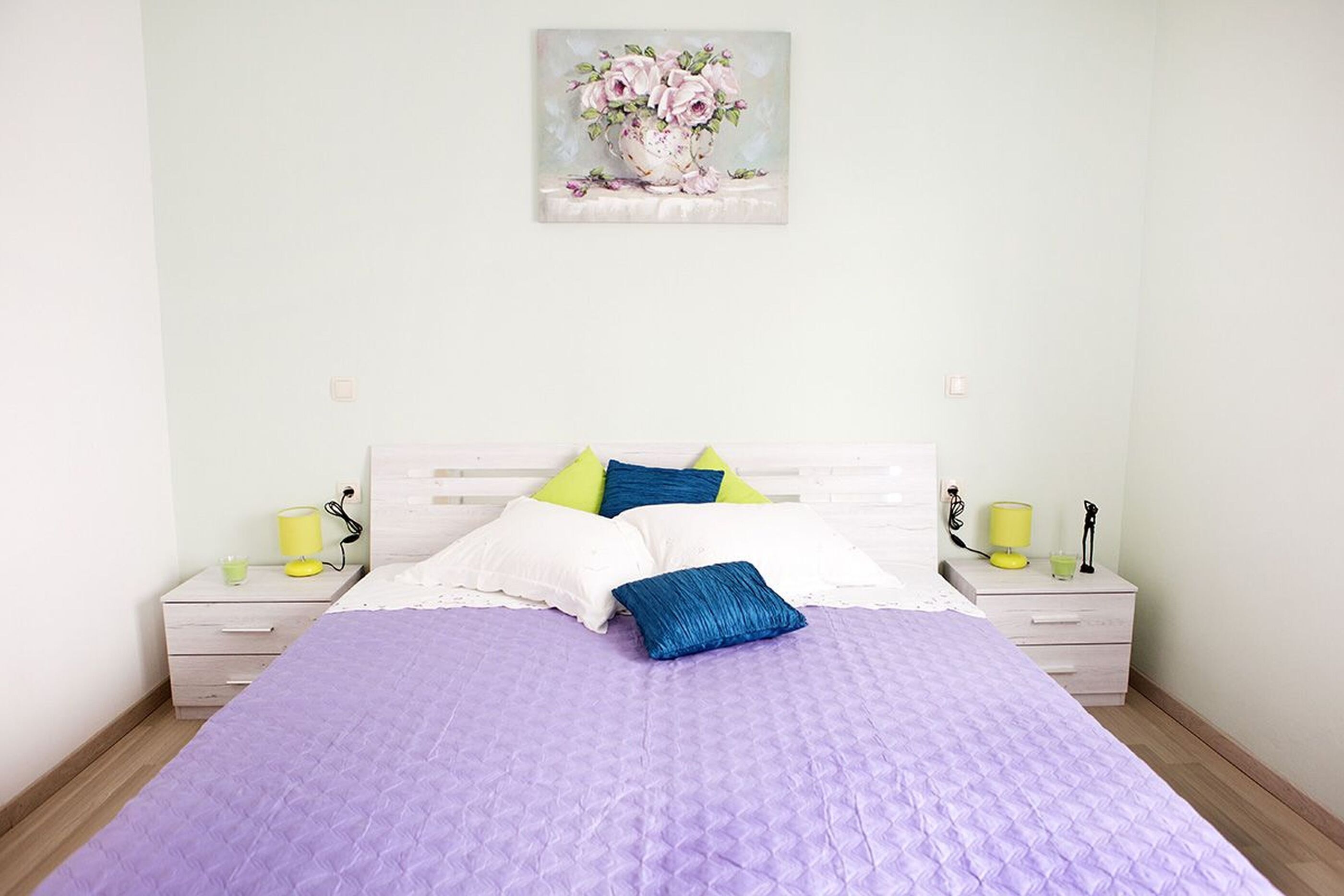 Une chambre à coucher avec un lit, deux tables de chevet et une petite table d’appoint.