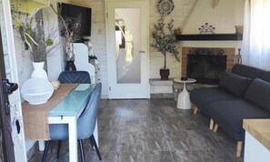 A cozy living room with a fireplace, a dining area with a table and chairs, and a sofa. - House Silvana (Postira)