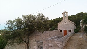Eine Steinkirche mit einem Glockenturm, einer Holztür und einer Treppe, die zu ihr hinaufführt.