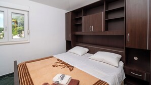 Une chambre à coucher avec un lit, une fenêtre et une armoire.
