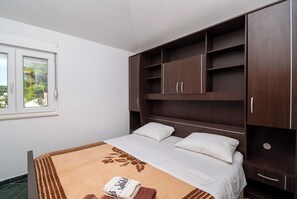 A bedroom with a bed, a window, and a wardrobe. - Apartments Branko (Tisno)