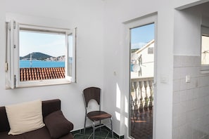 A room with a view of the sea, a balcony, a sofa, and a chair. - Apartments Branko (Tisno)