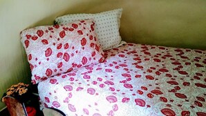 Ein Bett mit gemusterten Betttextilien und zwei Kissen.