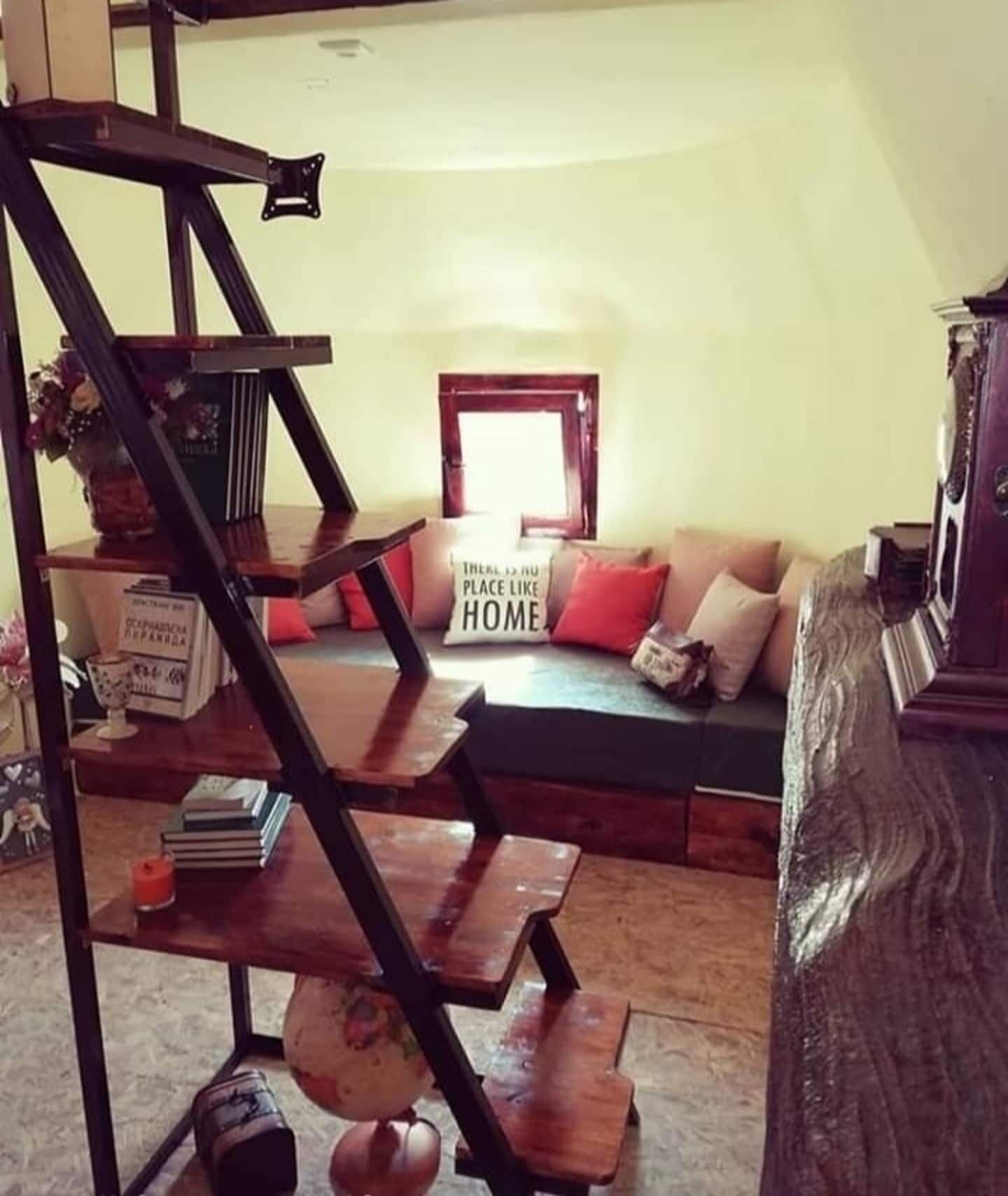 Ein Wohnzimmer mit Treppe, Sofa und einem Schild mit der Aufschrift 'There is no place like HOME.'