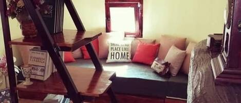 Ein Wohnzimmer mit Treppe, Sofa und einem Schild mit der Aufschrift 'There is no place like HOME.'
