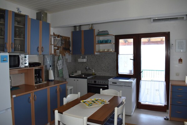 A compact kitchen with a dining area, featuring cabinets, a microwave, a stove, and a sink. - Apartment Marijana (Seget)