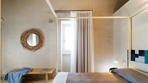 A bedroom with a bed, a bedside table, a mirror, a window with curtains, and a wall with a decorative panel. - Luxury villa with pool near Scicli (Scicli)