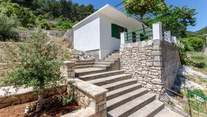Un edificio blanco con una escalera de piedra que conduce a una puerta verde.