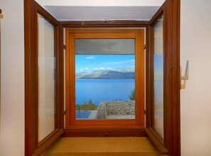 A wooden-framed door with a view of a lake and mountains. - House Krunoslav (Postira)