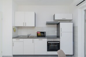 Apartment (A2) | Private kitchen | Fridge, microwave, oven, stovetop - Apartments Marina (Postira)