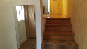 A staircase with wooden steps and a tiled landing area. - Apartments Soline (Podgora)