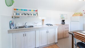 Eine Küche mit weißen Schränken, einer doppelten Spüle und einer Holz Arbeitsplatte.