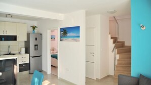 Eine moderne Wohnung mit Küche, Essbereich, Wohnzimmer und einer Treppe.