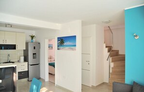 A modern apartment with a kitchen, a dining area, a living room, and a staircase. - House Josin san (Marina)