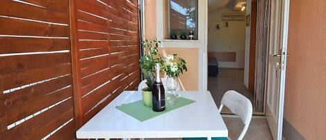 A patio with a table, chairs, and a bottle of champagne.
