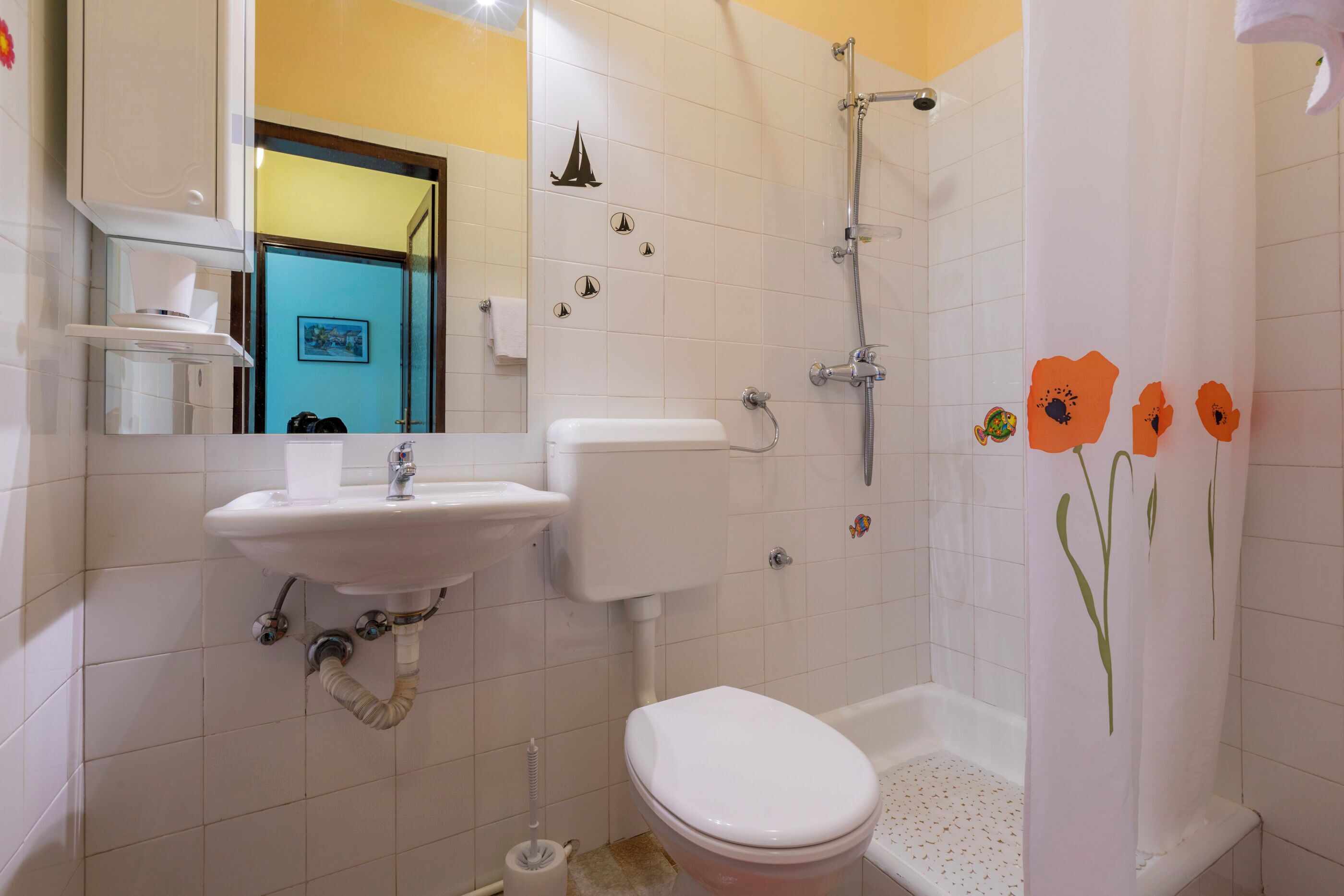 A bathroom with a toilet, sink, and shower.