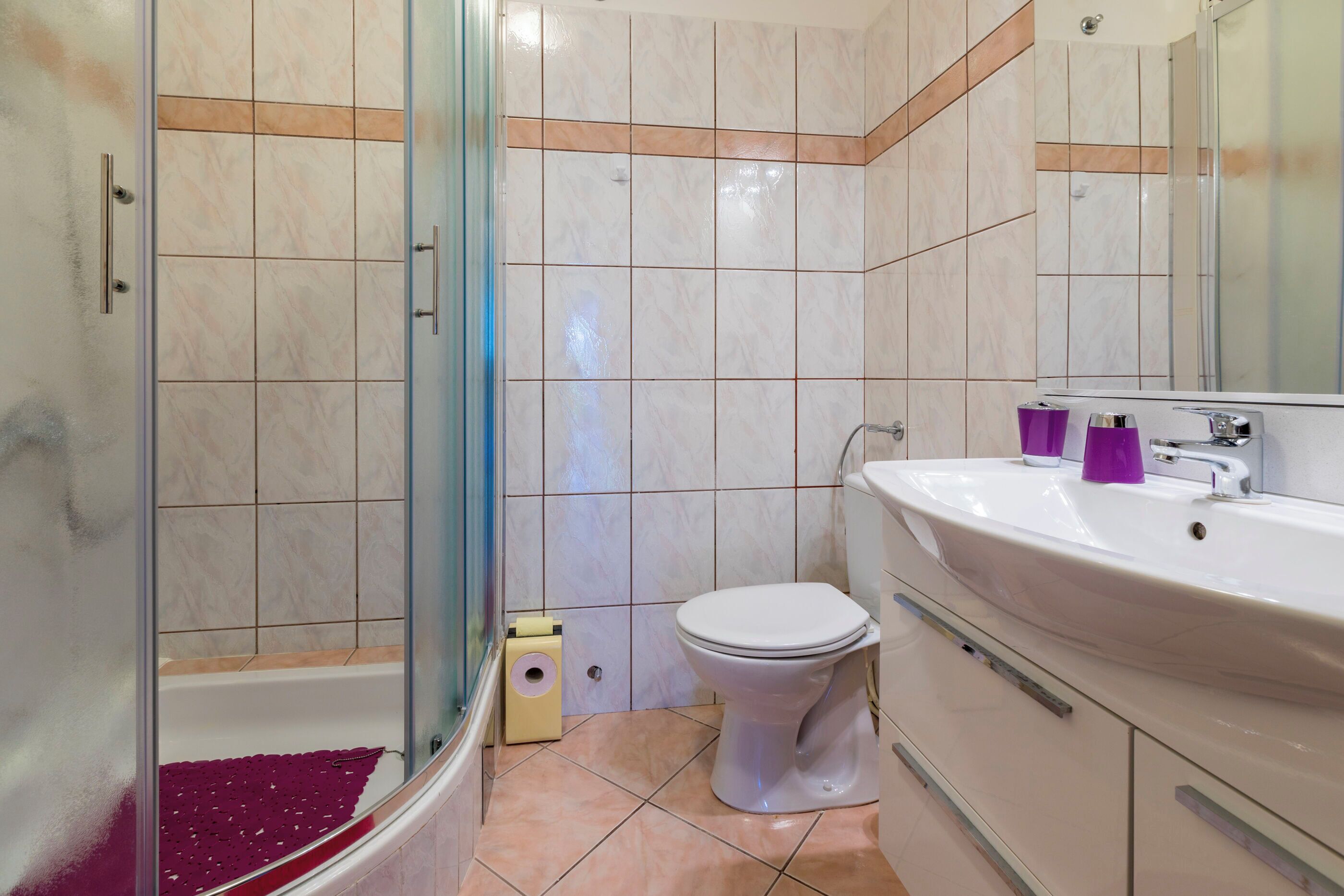 Un baño con ducha, inodoro y lavabo.