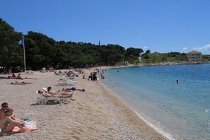 A beach with people sunbathing and swimming. - Apartments Vesna (Makarska)