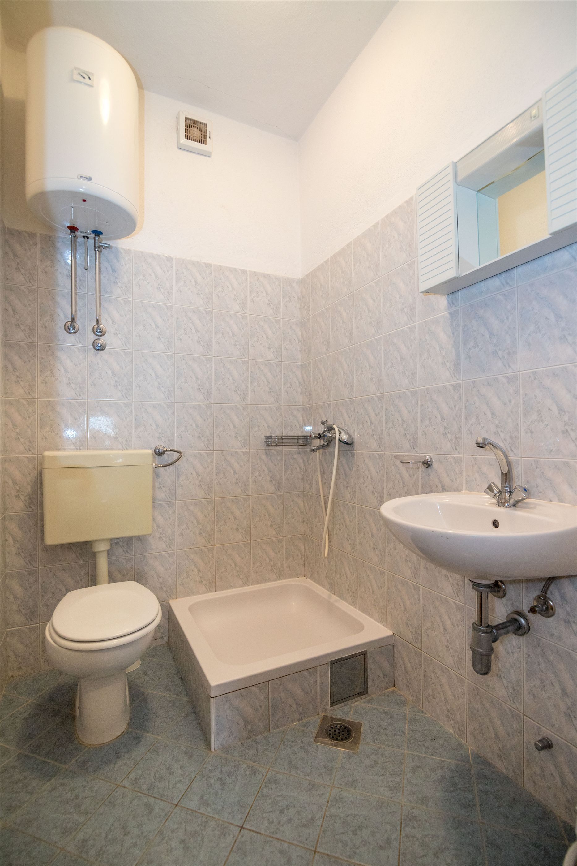 A bathroom with a toilet, a sink, and a shower.