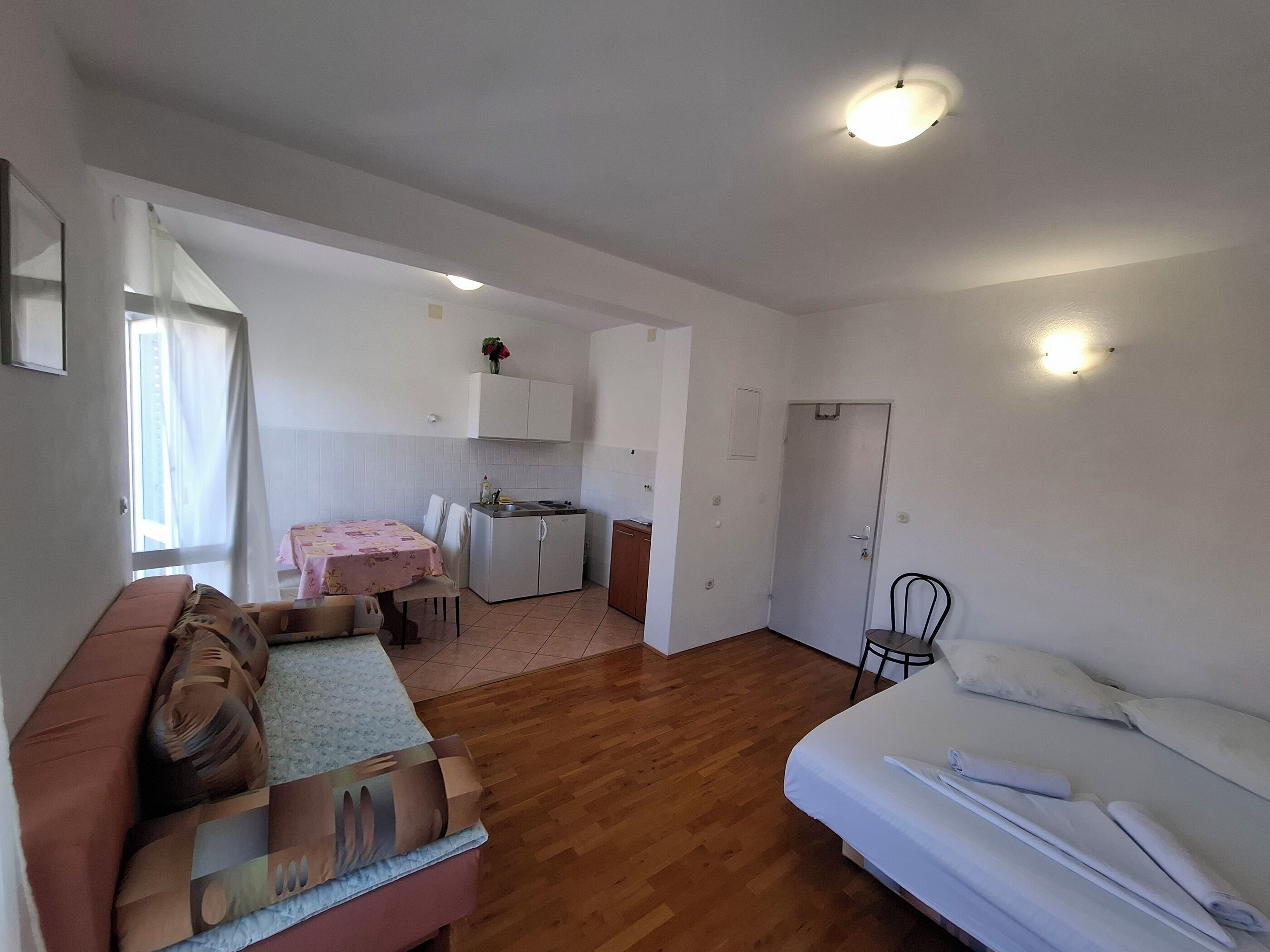 Ein kompakter Wohnraum mit Küchenzeile, Essbereich und Schlafzimmer.