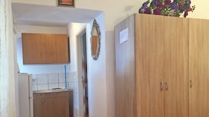 A kitchen with wooden cabinets, a white refrigerator, and a tiled backsplash. - Apartments Jelena (Sucuraj)