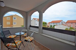 A balcony with a view of neighboring houses, a table with chairs, and a railing. - Apartment Lily With Pool Srima (Vodice)