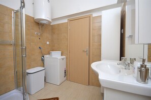 A bathroom with a shower, a sink, a toilet, and a laundry machine. - Apartment Lily With Pool Srima (Vodice)